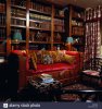 wooden-framed-sofa-with-red-upholstery-and-patterned-cushions-in-front-of-bookshelves-in-livin...jpg